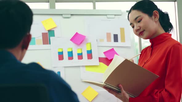 Young Woman Explains Business Data on White Board