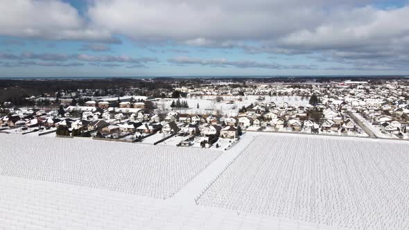 Aerial of farmland and neighboring town on a winter blue cloudy day Virgil, Ontario