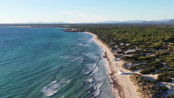 Trench Beach in Mallorca Island Spain with small house tents, Aerial flyover shot