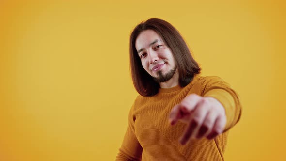 Caucasian Man with Brown Hair and Beard Pointing at Camera Holding Up Fake Paper Microphone Smiling