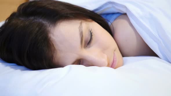 Young Woman Sleeping in Bed at Night