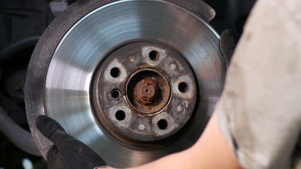 Worker Taking Off Car Brake Rotor