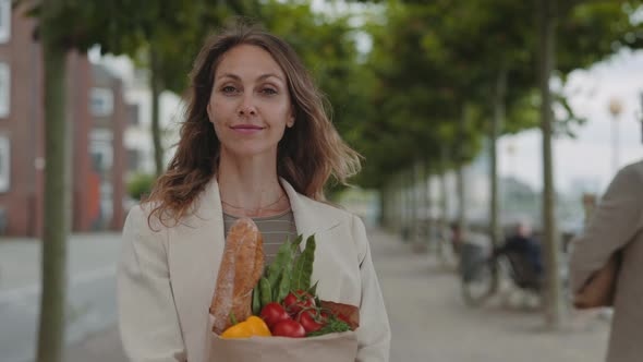 Portrait of Mature Woman Posing on Street with Grocery Bag