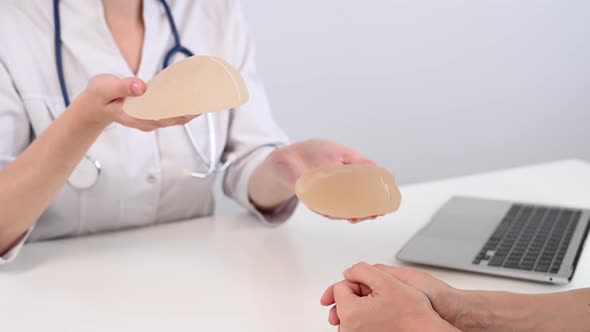 Caucasian Woman and Plastic Surgeon Choosing Breast Implants