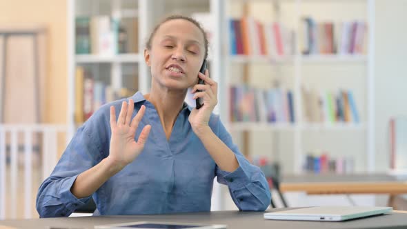 Upset African Woman Angry on Smartphone in Library