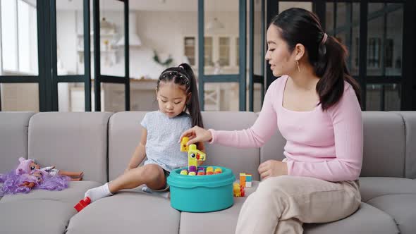 Asian Mother and Daughter Play with Toys Together at Home