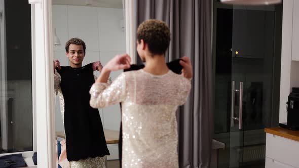A Man Trying His New Black Dress in Front the Mirror at Home