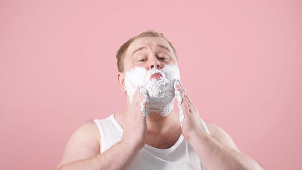 Happy Plump Man with Shaving Foam on His Face and Razor Isolated on Pink