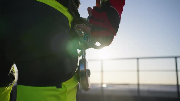 Closeup of an Industrial Climber Fastening a Carabiner with a Jumar to a Harness