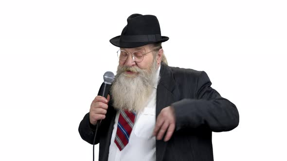 Elderly Entertainer Talking Into Microphone