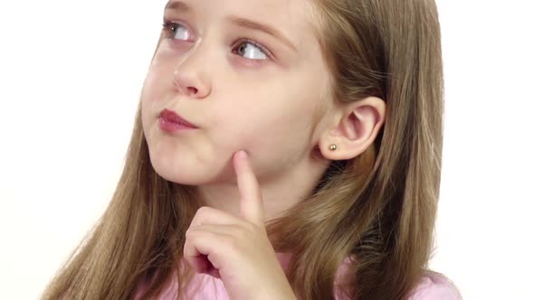 Baby Is Looking at the Side, She Is Thoughtful. White Background. Close Up. Slow Motion