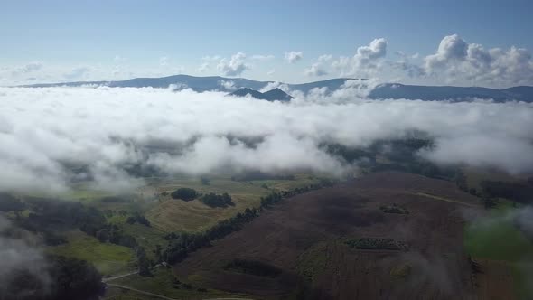 Flying Above Clouds With Mountains In Back