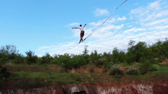 Aerial Footage of a Man Walking on the Slackline Blue Sky