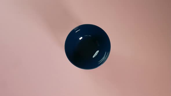 Packaged rotini being poured in a shallow blue bowl