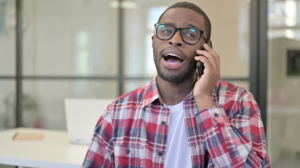 African Man Talking on Phone Discussing