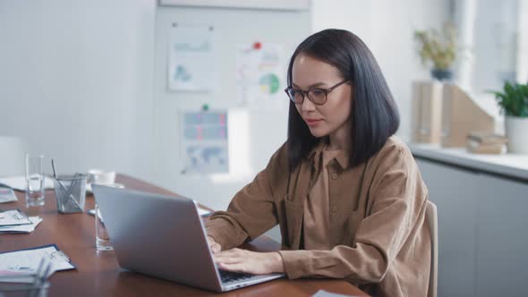 Asian Office Worker Using Laptop