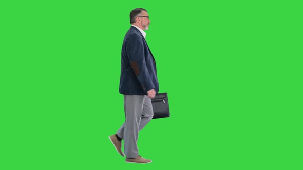 Old Business Man in a Hurry Looking at Watch and Walking Quickly on a Green Screen Chroma Key