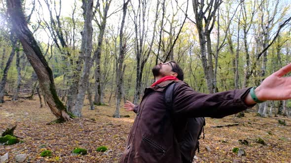 Satisfied Traveler Guy Stands in Picturesque Forest