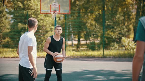 Friends Playing Basketball on the Sports Ground - a Man Aiming in the Hoop and Throwing the Ball