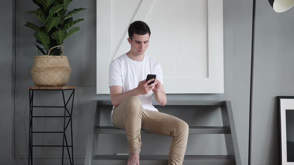 Man Using Mobile Phone Sitting on Stairs