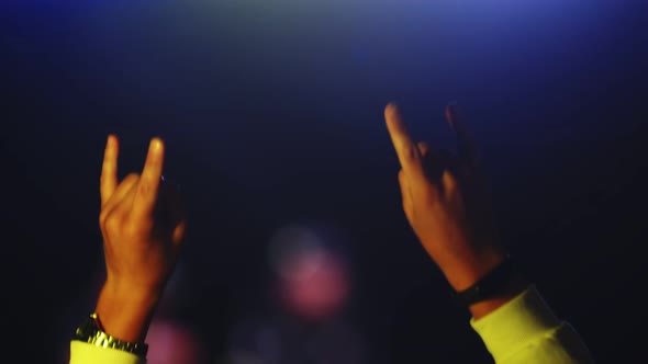 Hands of the Jumping Man Move to Beat of the Music at Concert and Show Rock Gesture Closeup Back