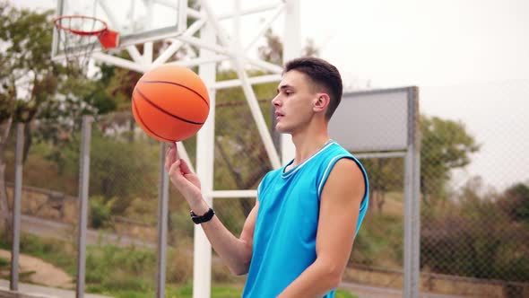 Portrait of a Basketball Player Spinning a Basketball on the Street Playground