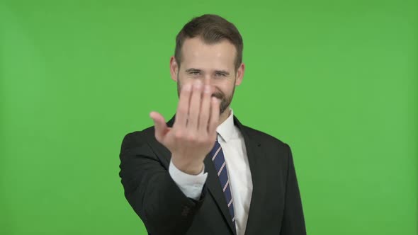 Cheerful Businessman Pointing Finger and Inviting Against Chroma Key