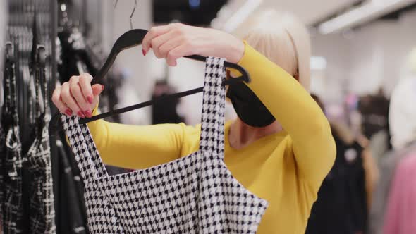 Mature Caucasian Female Shopper Customer in Protective Mask During Quarantine in Clothing Store