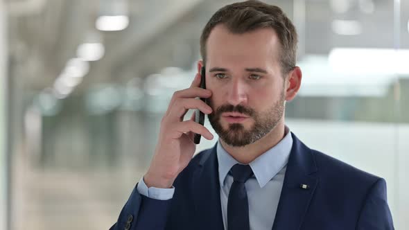 Portrait of Cheerful Businessman Talking on Smartphone