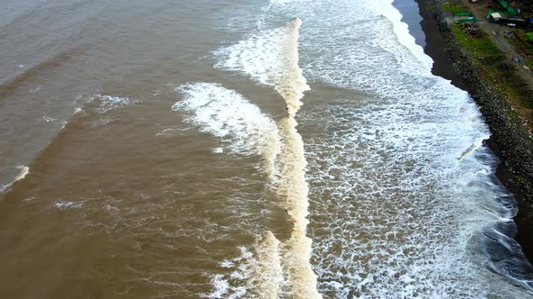 brown sea waves coming on beach of rajodi beach black sand india mumbai maharshtra.