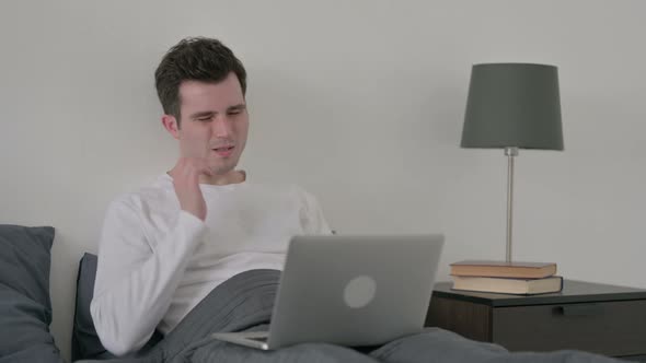 Man with Laptop Having Headache in Bed