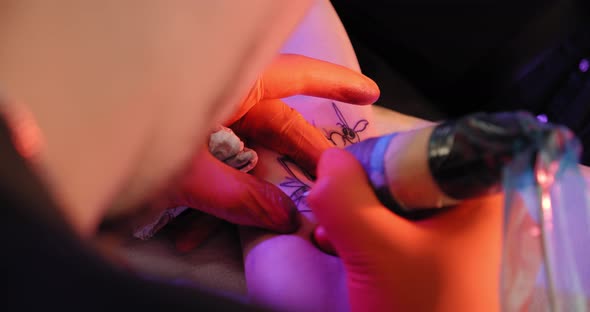 Tattoo Artist Makes a Tattoo on a Arm, Works in Studio. Close-up View Slow Motion Top View