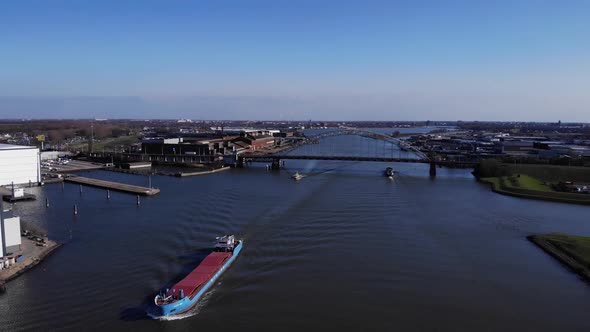 Merchant Ship In Idyllic Waterway With Bridge At Background In River Noord Near Hendrik-Ido-Ambach,