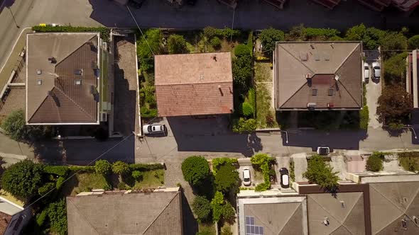 Top shot by drone of some houses in a small village, zoom in. Italy, Marches.