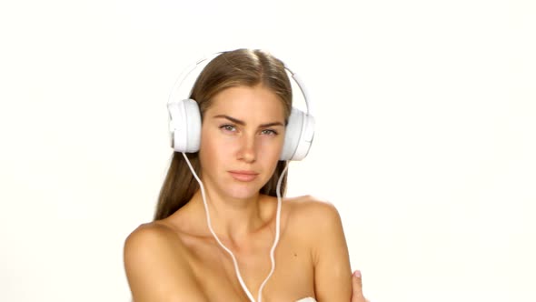 Sexy Woman in White Shirt Listening and Dances for the Music Using Headphones