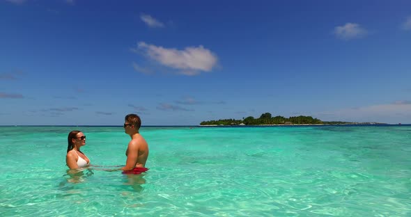 Fun man and woman on romantic honeymoon spend quality time on beach on sunny white sandy 4K backgrou