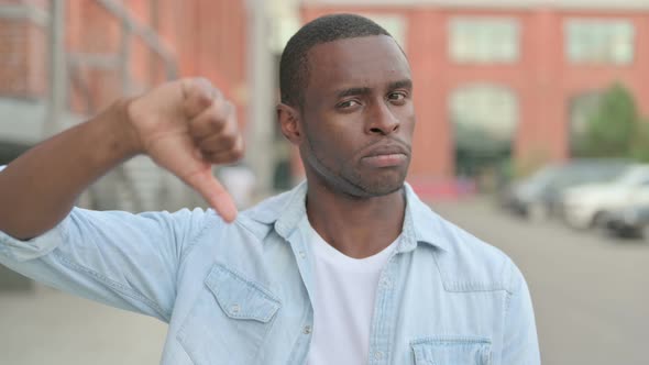 Portrait of African Man Showing Thumbs Down Gesture Outdoor