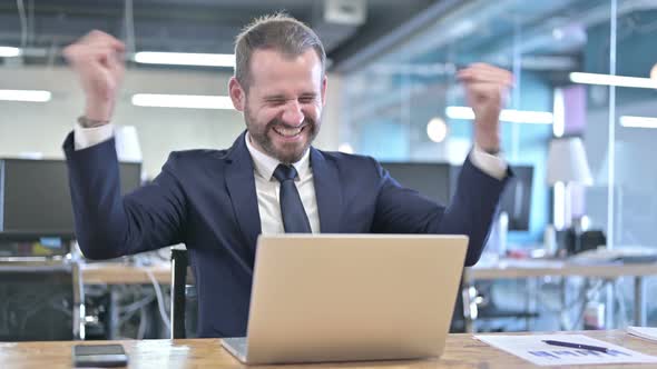 Surprised Young Businessman Celebrating with Both Fist