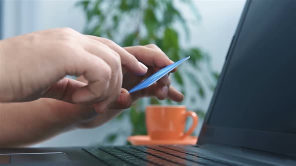 Man Holding Credit Card And Entering Security Code