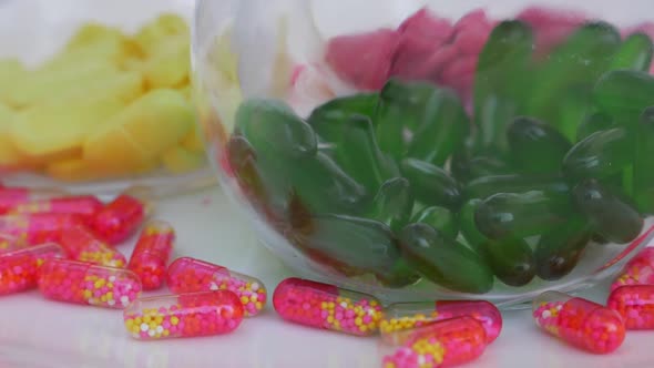 macro shot of green tablets in a glass bottle with pink capsule around