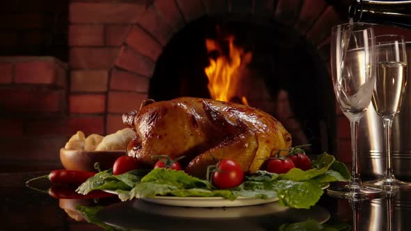 Champagne Is Poured Into Glasses Next To the Plate with Delicious Baked Chicken