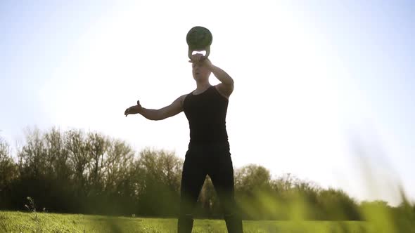 Athletic Male Lifting Up the Poise in Black Coloured Sports Wear