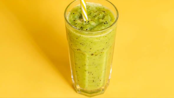 Fresh Green Juice with Kiwi on Yellow Background