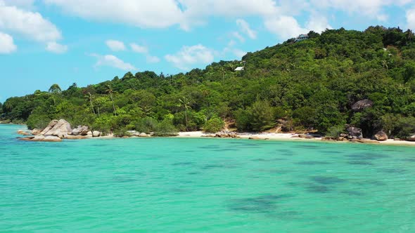 secluded sandy beach and rocky coast with palm forest on the hills. Thailand