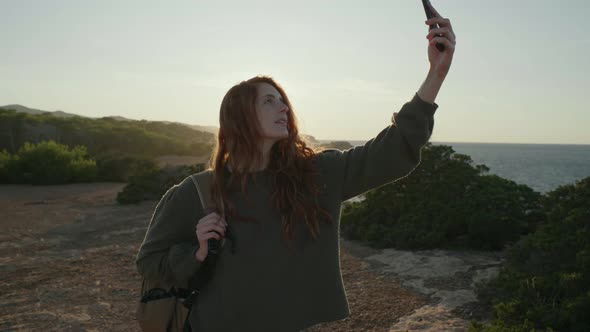 Slow motion shot of happy redheaded woman taking a selfie