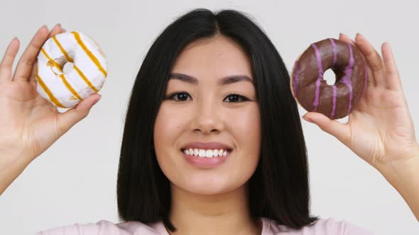 Happy Asian Woman Posing With Donuts Standing Over White Background