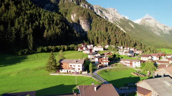 Aerial View of an Austrian Village in a Green Mountain Valley at Sunset Alps