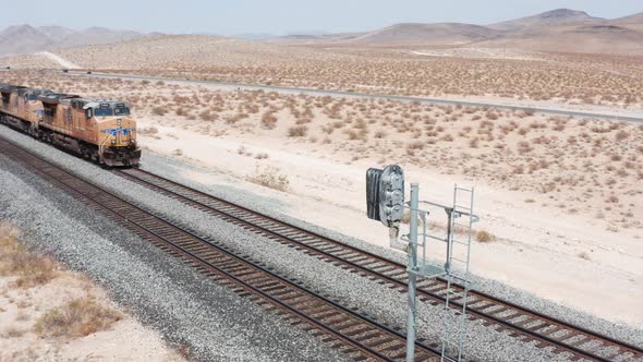 Freight Tain moving Aerial Footage. Freight train rides on the railroad in the desert.