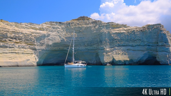 4K Dramatic Cliffs and Crystal Clear Water on the Greek island of Milos with Sail Boats Anchored