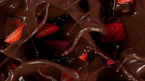 Super Slow Motion Shot of Fresh Cutted Strawberries Falling Into Melted Chocolate at 1000 Fps